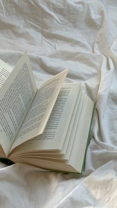 an open book sitting on top of a white sheet