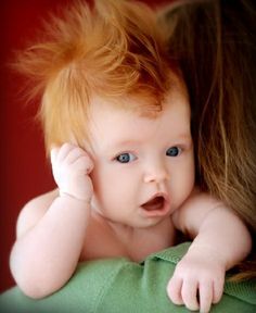 a close up of a baby laying on its mother's shoulder