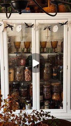 an old china cabinet filled with lots of jars