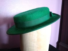 This handmade hat can work for multiple eras! Tilt it to the side for 1930s or 1940s, or wear it straight across for a turn of the century look. Since this hat sits at the top of the head, it will fit most head sizes. As such, it will need to be secured with something, like a hat pin. Fitted Green Fedora For Kentucky Derby, Green Tailored Brimmed Fedora, Fitted Green Brimmed Fedora, Green Fitted Flat Brim Felt Hat, Green Fitted Felt Hat With Flat Brim, Retro Fitted Brimmed Felt Hat, Classic Green Hat For Kentucky Derby, Classic Green Fedora For Kentucky Derby, Vintage Green Mini Hat With Short Brim