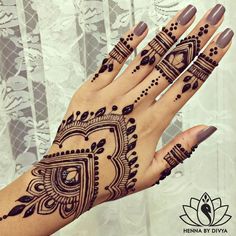 a woman's hand with henna tattoos on it and an intricate design on the palm