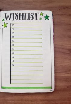 a wish list with green stars on it sitting on top of a wooden table next to a pen