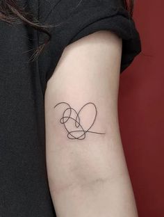 a woman's arm with a tattoo on it that has two intertwined hearts