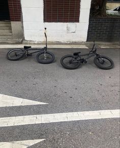 two bikes parked next to each other on the street