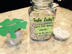 a jar filled with lots of candy next to a cut out of a green frog