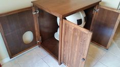 a soccer ball sits in the corner of a wooden storage unit with two doors open