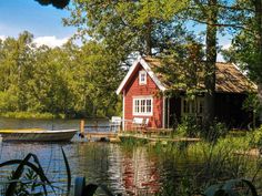 a small red house sitting on top of a lake