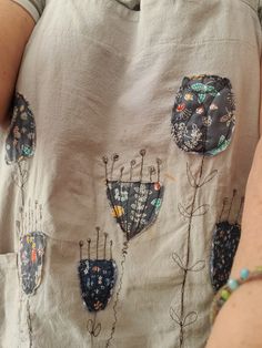 a woman is wearing an embroidered shirt with flowers on it