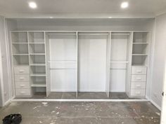 an empty room with white closets and drawers in the process of being painted gray