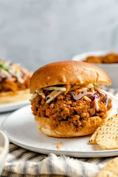 a sloppy joe sandwich on a plate next to some crackers and other food items