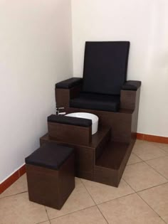 a chair and ottoman sitting on top of a tile floor next to a white wall