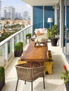 a balcony with chairs, tables and potted plants on the outside patio overlooking cityscape