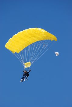 a person is parasailing in the air with a yellow parachute attached to it