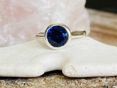 "This beautiful ring contains a 2.00 ct. lab created Blue Sapphire. The center stone measures 8mm. The ring is available in sterling silver, and 14k white or yellow gold. The mounting is a modern, high polish, heavyweight setting. This ring makes a great gift for a birthday, Mother's Day, bridesmaids, or any other special occasion. This ring could also be \"something blue\" for a wedding. Blue is the birthstone color for September. Please send me a message if you need a size not listed. *Matchin Engagement Ring Bezel, Oval Sapphire Ring, Sapphire Solitaire Ring, Bezel Engagement Ring, Wedding Blue, Ring Sapphire, Cz Rings Engagement, Ring Bezel, Sapphire Solitaire