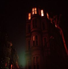 a tall building with windows lit up at night