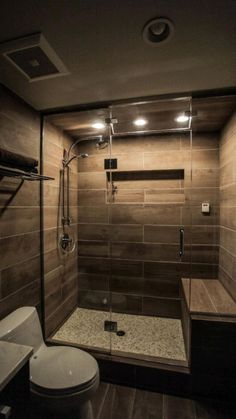 a bathroom with a walk in shower next to a toilet