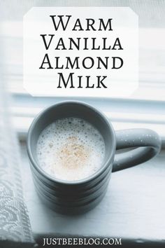 a cup of coffee sitting on top of a window sill next to a book