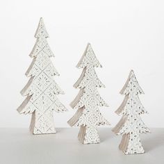 three white wooden christmas trees sitting next to each other