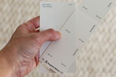 a person holding some white paint samples in their hand