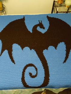 a crocheted blanket with an image of a dragon on it