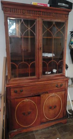 an old wooden china cabinet with glass doors