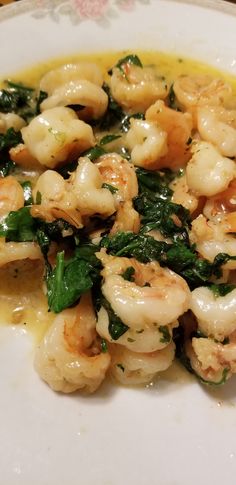 a white plate topped with shrimp and spinach