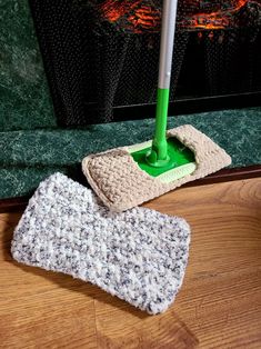 a mop and mitt sitting on the floor in front of a fireplace