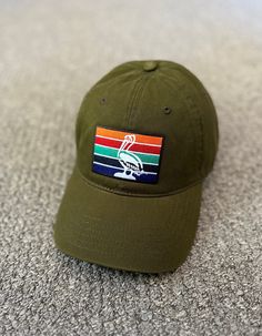 a green hat with the flag of south africa on it sitting on top of carpet