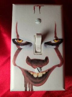 a light switch cover with an evil clown face painted on it