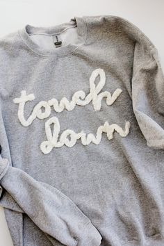 a gray sweatshirt with the words tough down on it