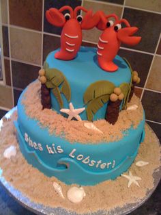 there is a blue cake with two crabs on it and starfish in the sand