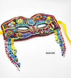 a masquerade mask is adorned with beads