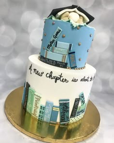 a three tiered cake with blue and white frosting, decorated with different types of books