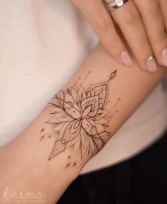 a woman's arm with a flower tattoo on the left side of her arm