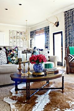 a living room filled with lots of furniture and flowers on top of a coffee table