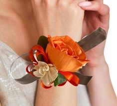 a woman wearing an orange flower on her wrist with a knife in the other hand