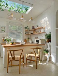 a kitchen with two chairs and a table in the center, under a skylight