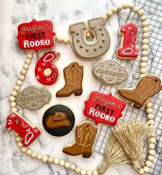 decorated cookies are arranged in the shape of cowboy boots and boots on a wire rack