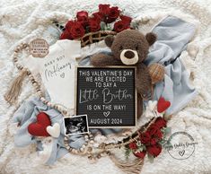 a teddy bear and other items are arranged in a heart - shaped frame on a blanket