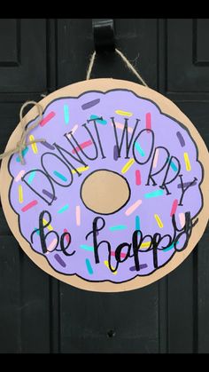 a donut sign that says don't worry be happy hanging on a door