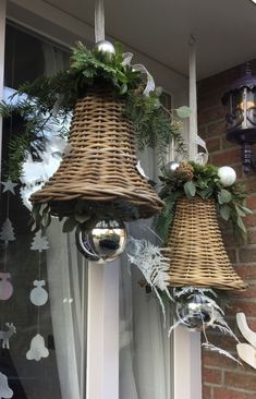 two christmas decorations hanging from the side of a window