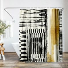 a shower curtain with black and white designs on it, next to a bathtub