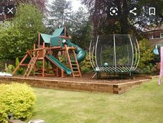 a wooden play set in the middle of a yard with a slide and climbing frame