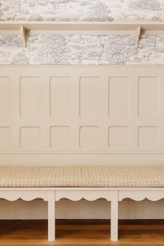 a white bench sitting on top of a hard wood floor