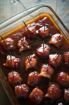 meatballs with toothpicks in a glass casserole dish on a wooden table