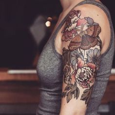 a black and white photo of a woman's arm with flowers on it