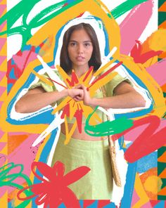 a woman standing in front of a colorful background holding her hands out to the side