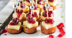 small appetizers with cranberry sauce and silver spoons on a white plate