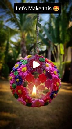 a flower ball hanging from a rope with a candle in it and the words let's make this