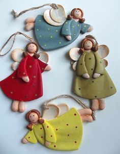 three ceramic angel ornaments hanging from twine